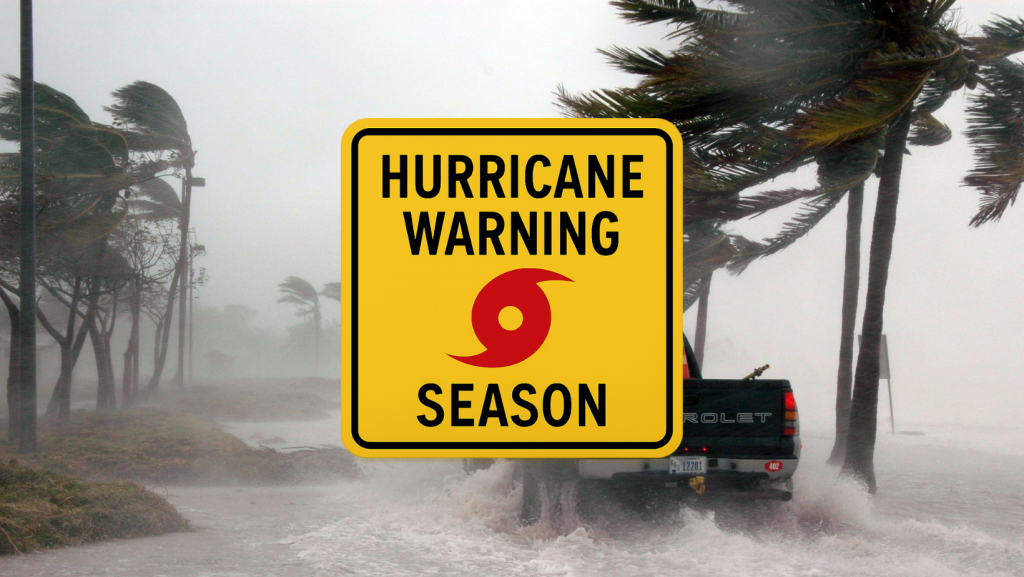 Yellow hurricane warning sign with bold black text reading "HURRICANE WARNING HURRICANE SEASON" and a red hurricane symbol in the center.